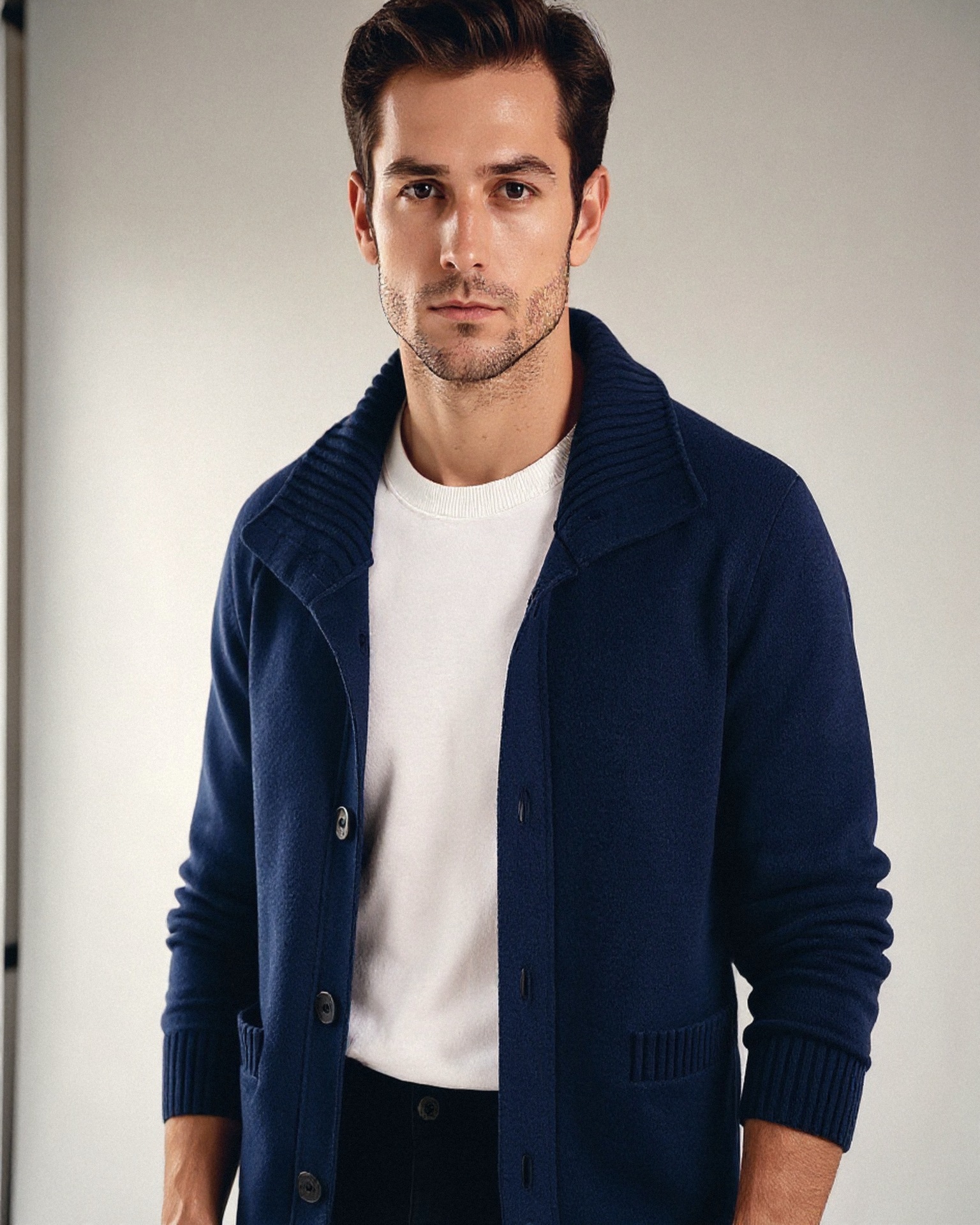 Man in een donkerblauwe gebreide cardigan met kraag
