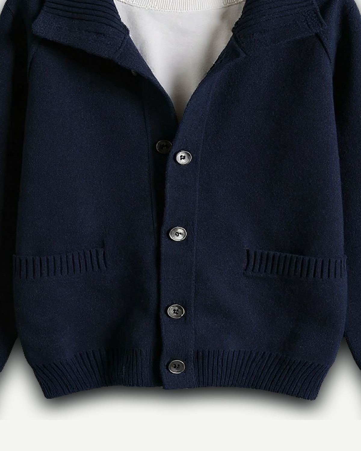Detail van de navy cardigan: kraag, buttons en gebreide structuur